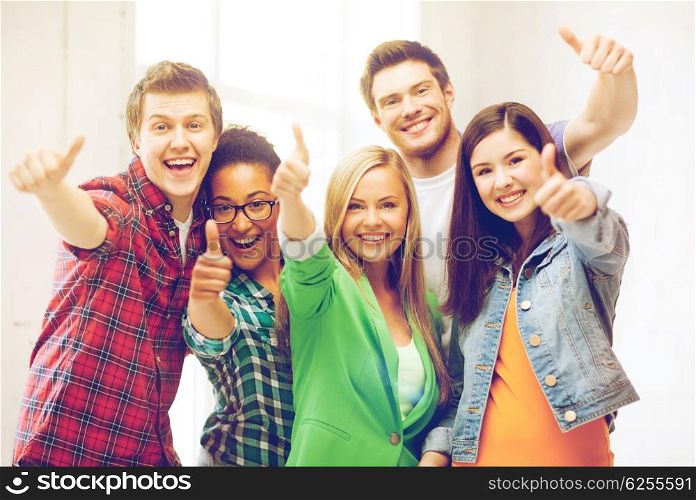 education concept - happy team of students showing thumbs up at school. students showing thumbs up at school