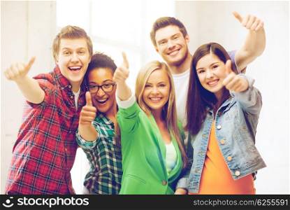 education concept - happy team of students showing thumbs up at school. students showing thumbs up at school