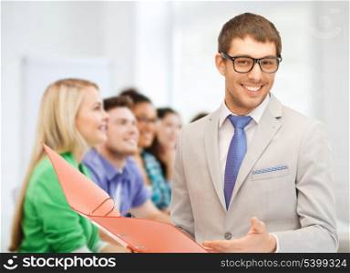 education concept - male teacher doing lecture at school