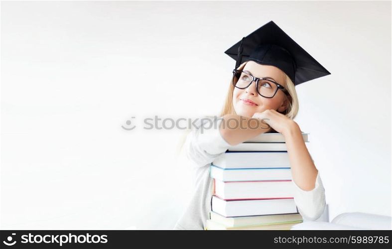 education concept - picture of happy student in graduation cap with stack of books. student in graduation cap