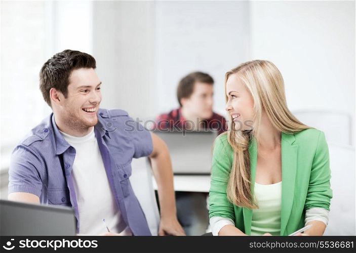 education concept - picture of smiling students looking at each other at school