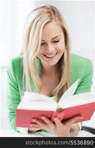 education concept - picture of smiling young woman reading book at school