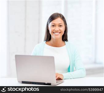 education concept - smiling international student girl with laptop at school