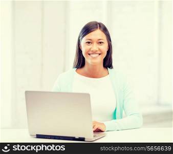 education concept - smiling international student girl with laptop at school