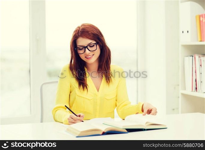 education concept - smiling student girl in eyeglasses reading books ana taking notes in library