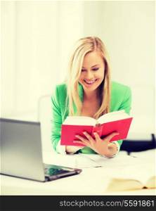 education concept - smiling student girl reading book in college