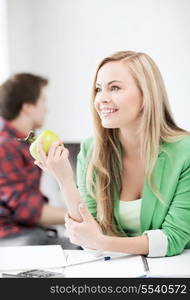 education concept - smiling student girl with green apple in college