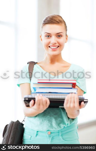 education concept - smiling student with folders and school bag in college