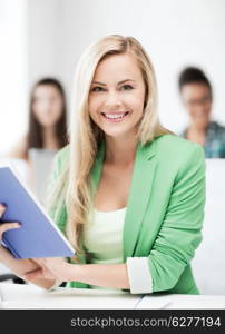 education concept - smiling young girl reading book at school