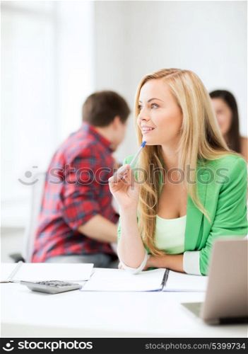 education concept - student girl with notebook and calculator in college