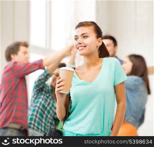 education concept - student holding take away coffee cup in college