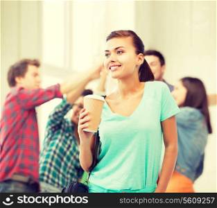 education concept - student holding take away coffee cup in college
