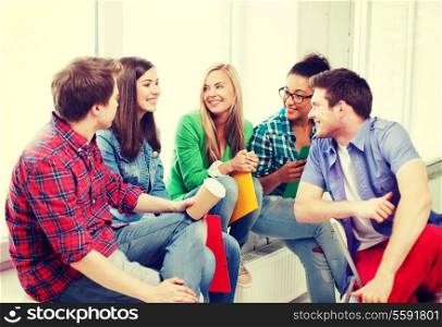 education concept - students communicating and laughing at school