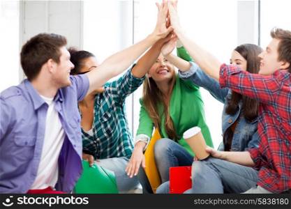 education concept - students giving high five at school
