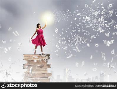 Education concept. Woman in red dress standing on pile of books