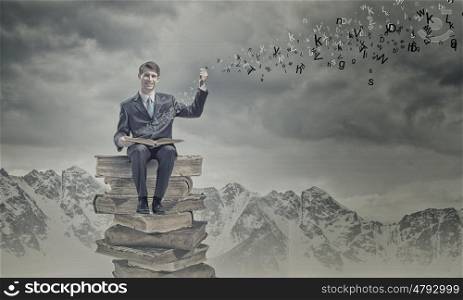 Education concept. Young businessman sitting on pile of books