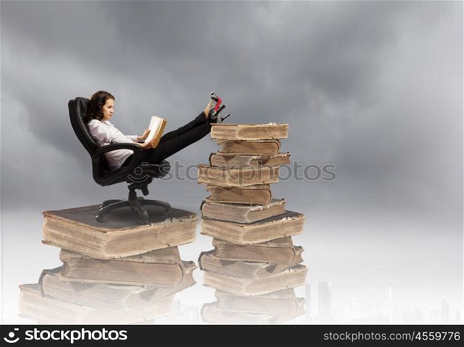 Education concept. Young businesswoman sitting in chair and reading book