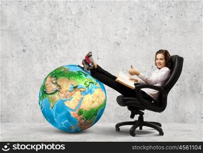 Education concept. Young businesswoman sitting in chair and reading book. Elements of this image are furnished by NASA