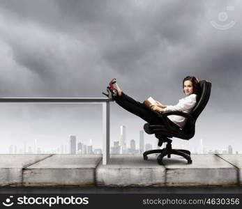 Education concept. Young businesswoman sitting in chair and reading book