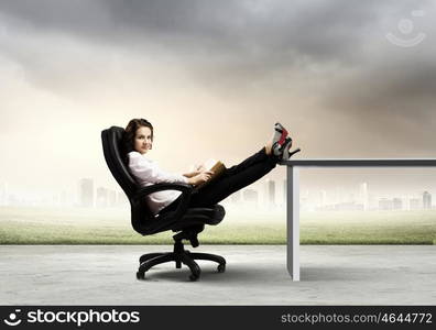 Education concept. Young businesswoman sitting in chair and reading book