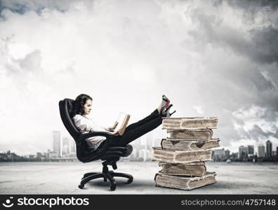 Education concept. Young businesswoman sitting in chair and reading book