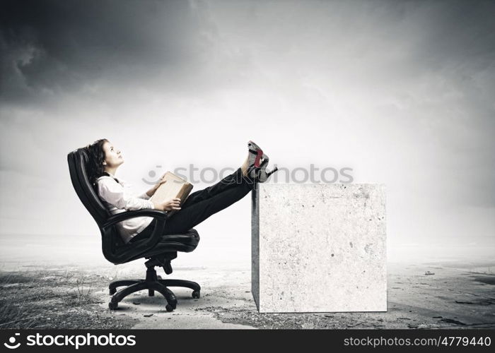 Education concept. Young businesswoman sitting in chair and reading book