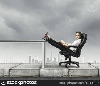 Education concept. Young businesswoman sitting in chair and reading book