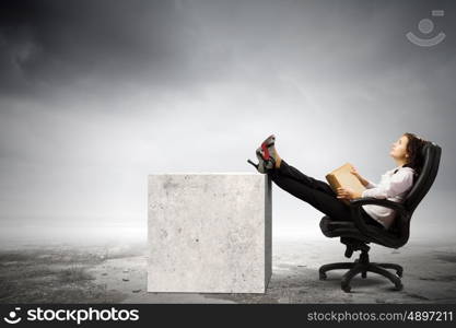 Education concept. Young businesswoman sitting in chair and reading book