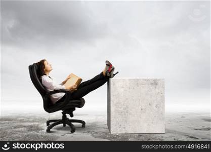 Education concept. Young businesswoman sitting in chair and reading book