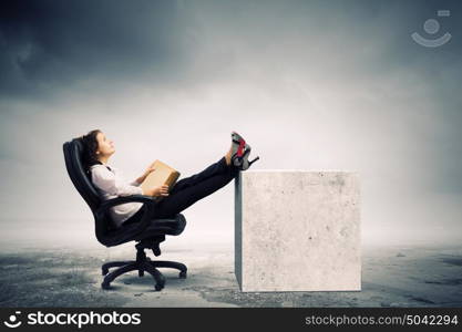 Education concept. Young businesswoman sitting in chair and reading book