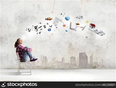 Education concept. Young girl sitting on chair with icon flying above