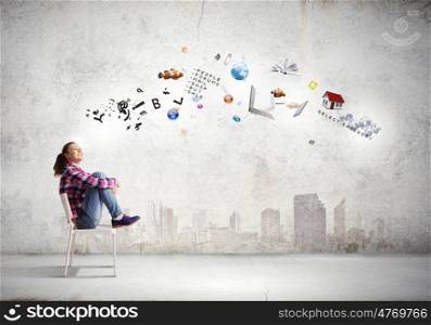 Education concept. Young girl sitting on chair with icon flying above