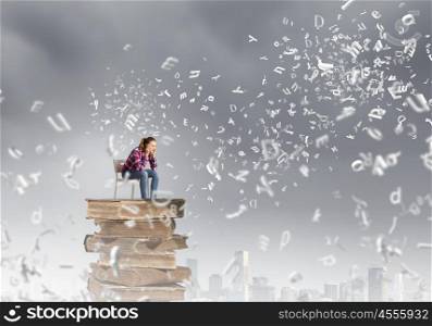 Education concept. Young girl sitting on high pile of books