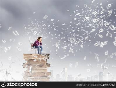 Education concept. Young girl sitting on high pile of books