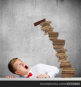 Education concept. Young handsome businessman and falling pile of books