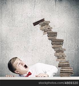 Education concept. Young handsome businessman and falling pile of books