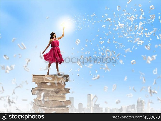 Education concept. Young woman in blindfold standing on pile of books
