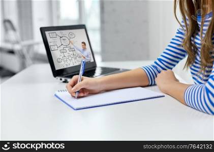 education, e-learning and school concept - close up of student girl with exercise book, pen and teacher on laptop computer having online lesson at home. student girl with exercise book, pen and laptop