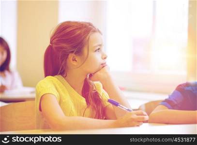 education, elementary school, learning and people concept - school girl with pen being bored in classroom