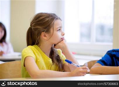 education, elementary school, learning and people concept - school girl with pen being bored in classroom