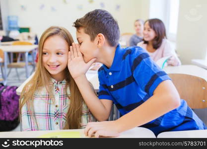 education, elementary school, learning and people concept - smiling schoolboy whispering secret to classmate ear in classroom