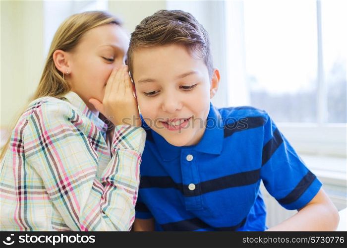 education, elementary school, learning and people concept - smiling schoolgirl whispering secret to classmate ear in classroom