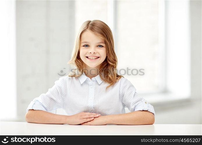 education, elementary school, learning, children and people concept - happy smiling girl sitting at table