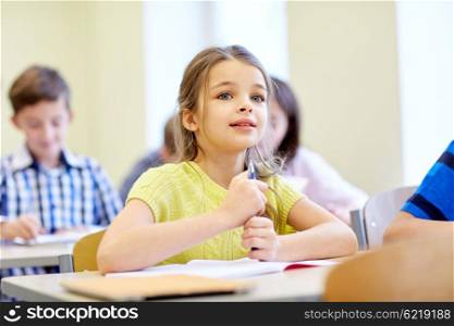 education, elementary school, learning, children and people concept - student girl with group of classmates on lesson in classroom
