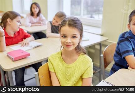 education, elementary school, learning, children and people concept - student girl with group of classmates in classroom