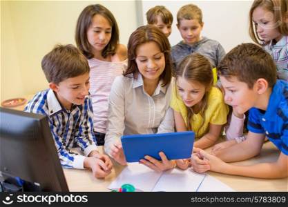 education, elementary school, learning, technology and people concept - group of school kids with teacher looking to tablet pc computer in classroom