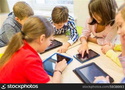 education, elementary school, learning, technology and people concept - group of school kids with tablet pc computer having fun and playing on break in classroom