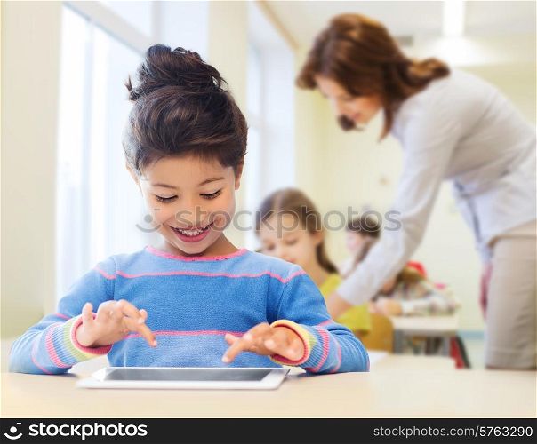 education, elementary school, technology and children concept - happy little student girl with tablet pc over classroom and teacher background