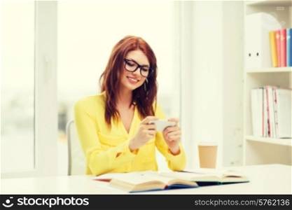 education, entretainment and technology concept - smiling student girl in eyeglasses with smartphone, books and takeaway coffee at school
