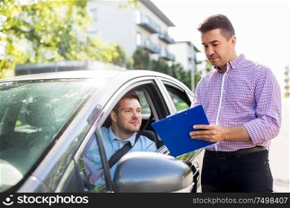 education, examination and people concept - driving school instructor with clipboard and male driver in car. car driving instructor with clipboard and driver